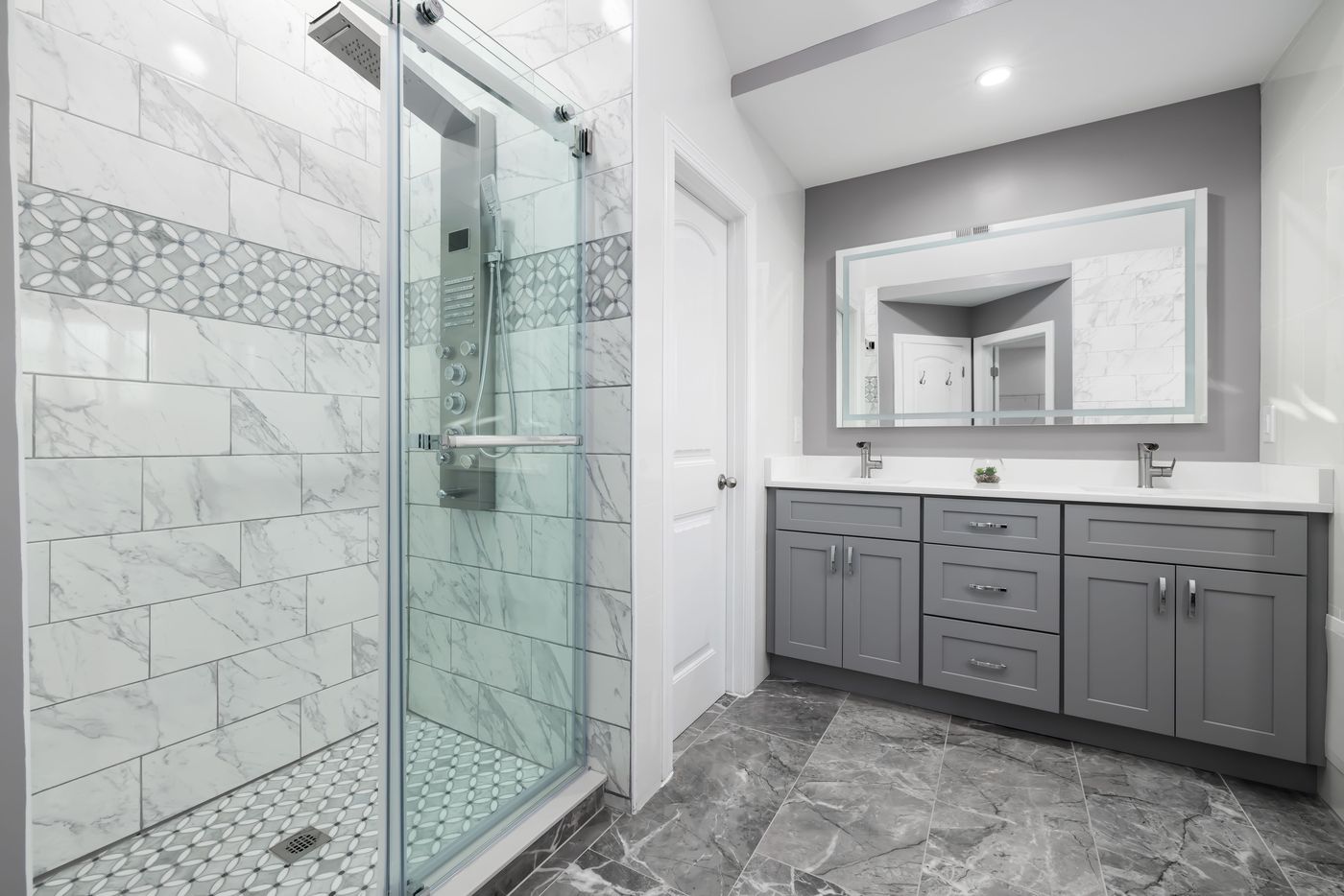 Double bathroom vanity with gray shaker cabinets and a tiled shower