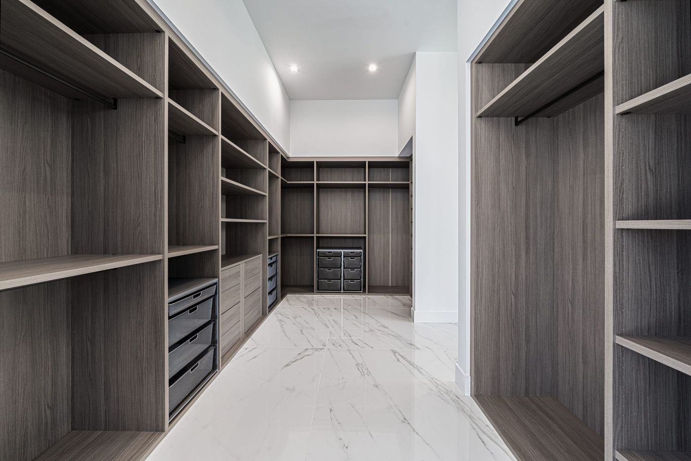 Walk-in closet with floor-to-ceiling shelving, drawers, and hanging rods